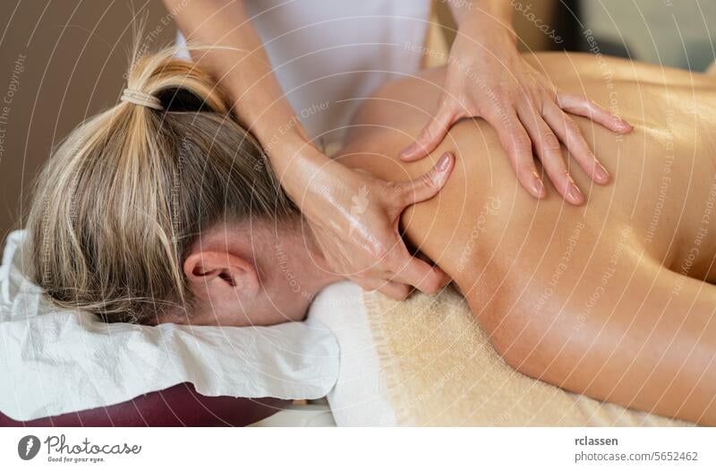 Massage therapist applying shoulder and back massage to a prone woman. beauty salon Wellness Hotel Concept image hotel massage oils physiotherapist asian
