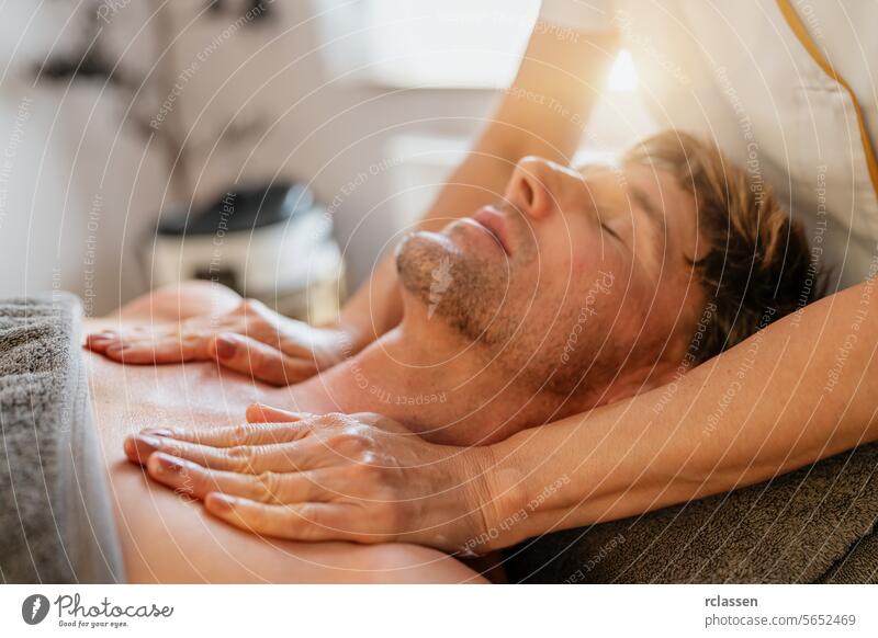 Man relaxing during a chest massage at a spa with a serene expression. Wellness Hotel Concept image asian hotel massage oils physiotherapist man relaxing