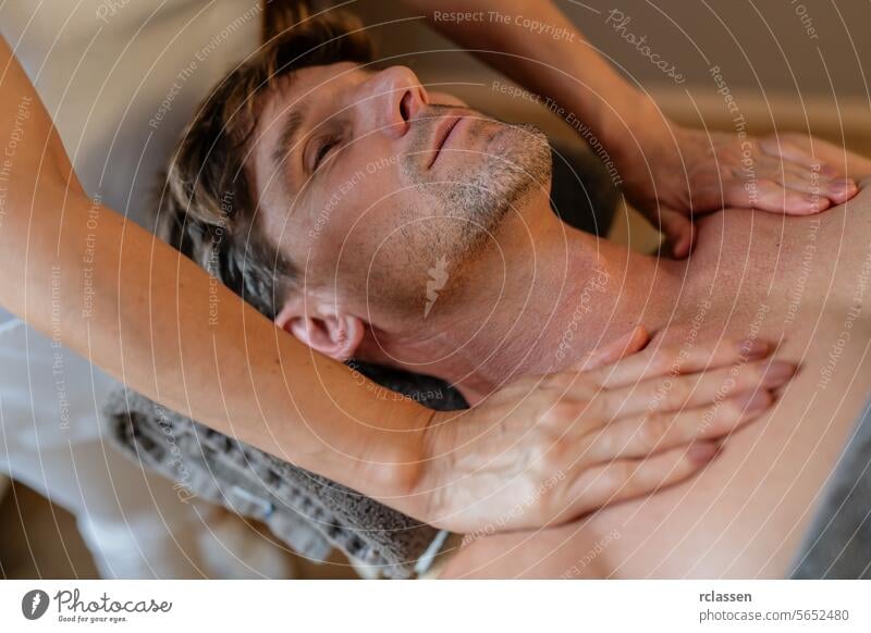 Man relaxing during a chest massage at a spa with a serene expression.Wellness Hotel Concept image resort hotel man neck massage close-up male patient