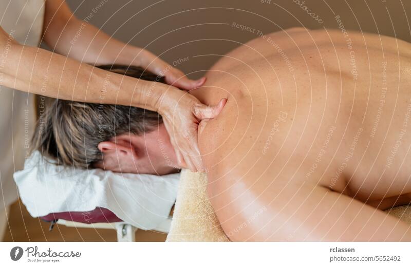 Therapist applying neck massage to a male client in a peaceful spa setting. Wellness Hotel Concept image resort hotel massage oils physiotherapist asian