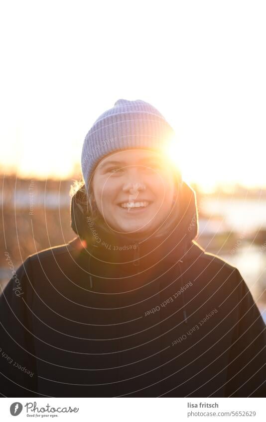 kissed by the sun Woman 18 - 30 years Cap Winter Modern Laughter Joy fortunate Warm light Sunlight Sunbeam Adults Exterior shot Colour photo Human being