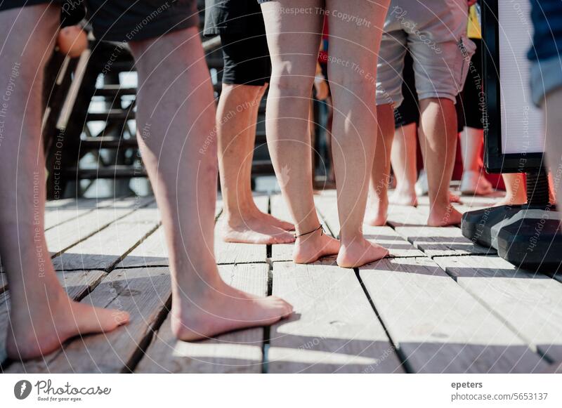 Legs of people standing in line in front of a chip shop on the North Sea beach Wait Queue wooden walkway Vacation & Travel Human being Footbridge Relaxation