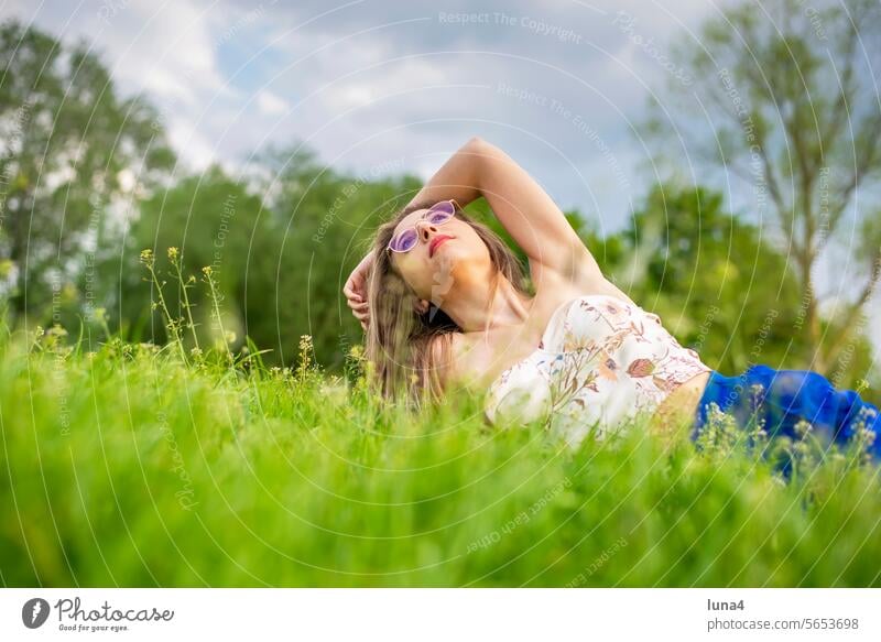 happy young woman with glasses lying on a meadow Woman fortunate youthful pretty sensual sunbathe daintily Single cheerful portrait Attractive optimistic
