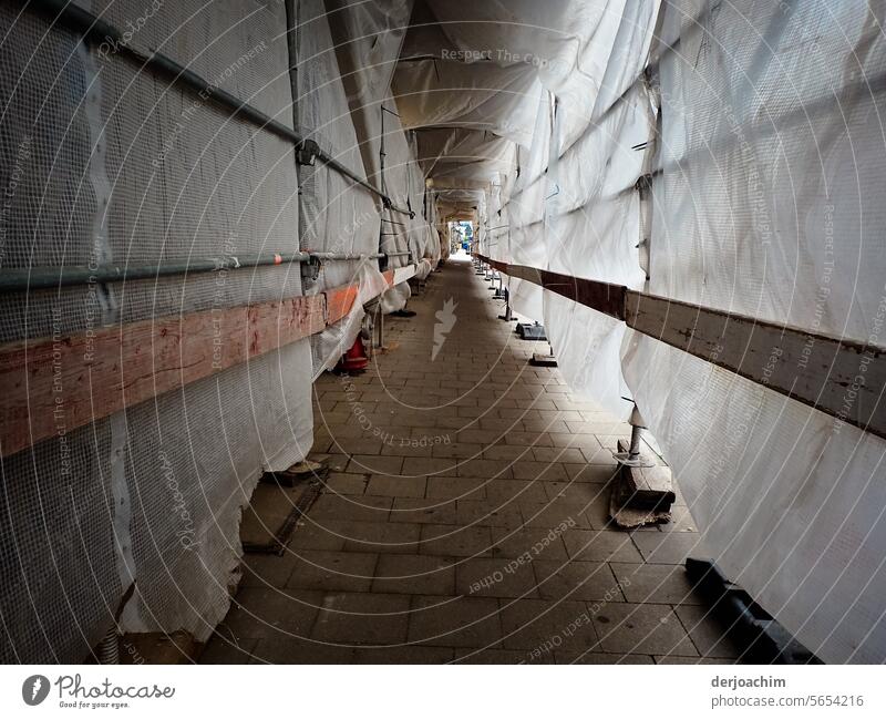 Covered and protected passageway with plastic tarpaulins for passers-by at a construction site. construction site safety Exterior shot Construction site Safety