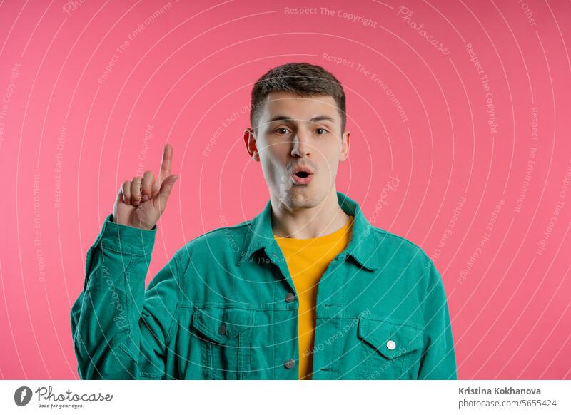 Brainy man having idea eureka moment, pointing finger up on pink. Solution. adult answer background casual caucasian cheerful confident expression face genius