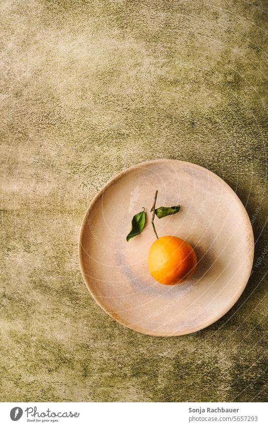 A single orange on a plate. Green background. Top view. Orange fruit Plate Fresh Fruit Vitamin Juicy cute Organic produce Vitamin C Food photograph plan