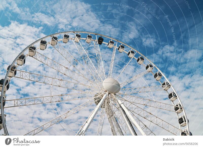 Ferris wheel rotates against background of blue cloudy sky ferris wheel attraction amusement park carousel fair fun recreation ride circle amusement ride