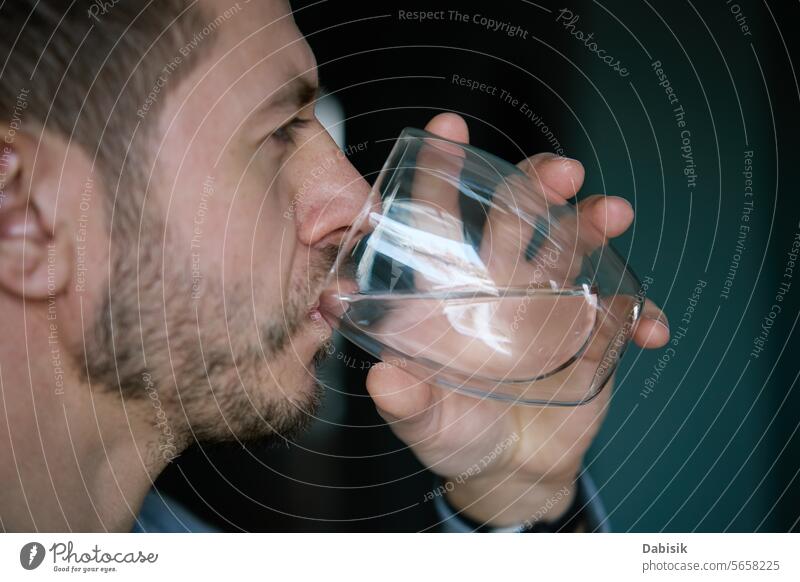 Man drinks clean water from glass man thirst fresh mineral healthcare metabolism beverage healthy pure clear adult water balance drinking water person mouth