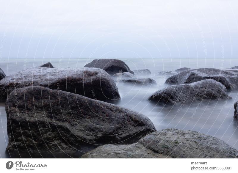 Long exposure of the wave movement on a rocky coast on a cloudy evening Baltic Sea stone coast Weather Dreary Evening Clouds overcast Gloomy stiene stones Rock