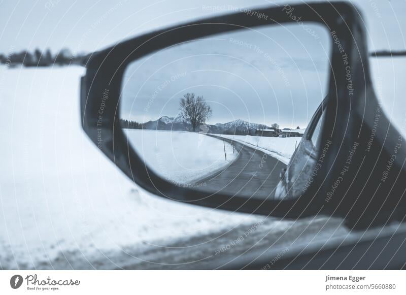 View through the side mirror in the car of a snowy and slippery road and surroundings Rear view mirror Bad weather Street Snow Smoothness Transport smooth