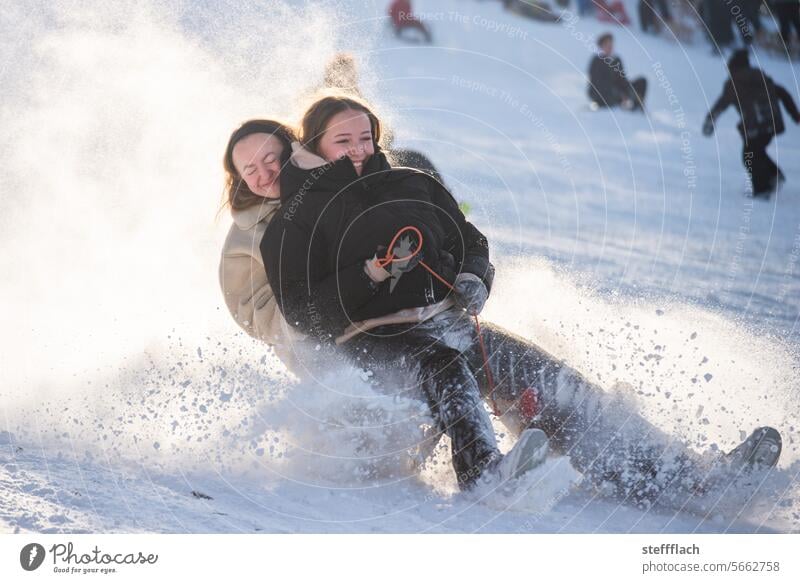 Two teenagers race through the sunshine on a sled, dusted with snow Snow Winter Sleigh sledging children Child Sunlight Sledding Sledge Toboggan run Cold