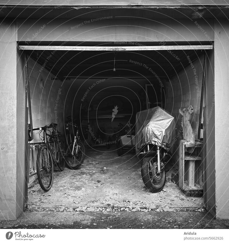 View into an open old garage b/w Garage Garage door Bicycle bicycles Motorcycle Covers (Construction) Motorcycle cover Handcart Keep Goal Vehicle