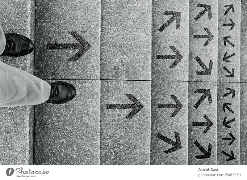 A woman stands on a staircase and has to decide which way she wants to go person Woman Stairs stagger direction Arrow Decide off down directional arrows feet
