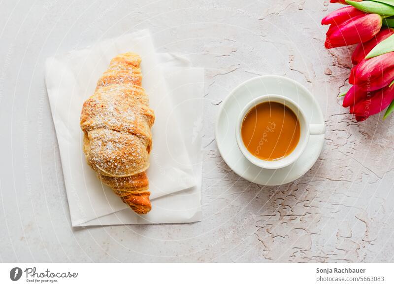 A cup of coffee, a croissant and pink tulips on a table. Top view. Coffee Cup Croissant Fresh Tulip Breakfast Morning Beverage Food Table Rustic Gray Saucer