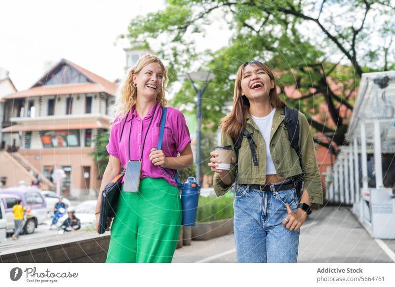 Cheerful multiethnic women walking outdoors, with one holding a coffee cup, in a relaxed, post-work setting in Chiang Mai, Thailand smiling cheerful smile Asian