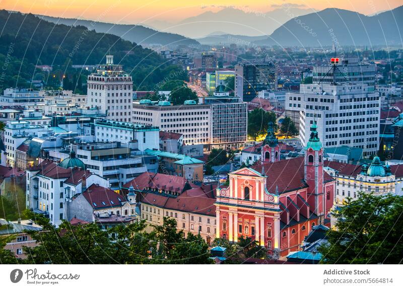 Aerial view of Ljubljana cityscape during sunset with historical red-roofed buildings and mountains in the background Slovenia urban skyline European capital