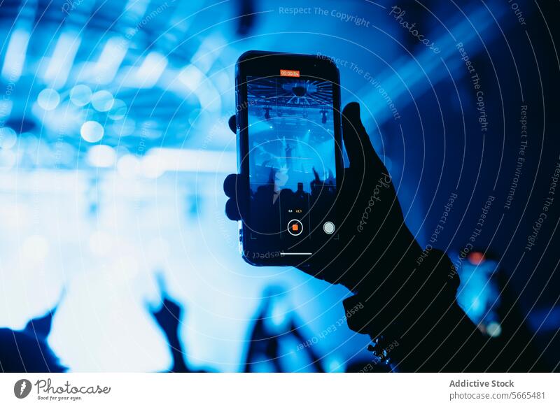 Capturing Concert Magic on a Smartphone smartphone concert recording audience hand silhouette stage light cheering live music performance screen entertainment