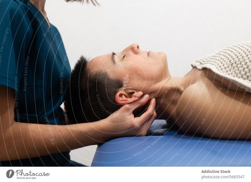 Chiropractor performing neck adjustment on patient chiropractor physical therapy male lying down professional treatment manipulation cervical spine