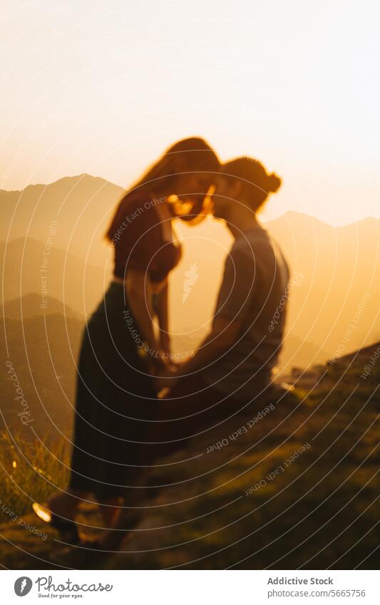 Romantic couple silhouette at sunset in mountains love romantic warm blurred touch forehead serene view evening nature outdoor scenery tranquil affection bond