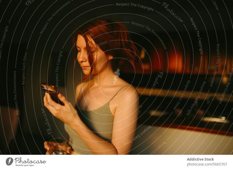 Serene woman using smartphone in dimly lit room serene tranquil lighting warm tone indoor comfort communication technology mobile browsing texting messaging