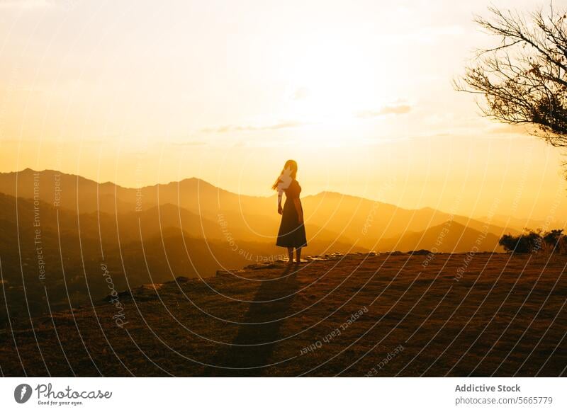 Silhouetted woman enjoying sunset over mountains in Minca, Colombia silhouette serene hill standing nature dusk tranquil landscape golden hour evening outdoors
