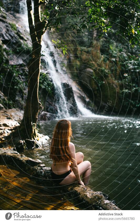 Tranquil moment by a tropical waterfall in Minca, Colombia person serene secluded sitting lush greenery nature tranquility peaceful calm relaxation female
