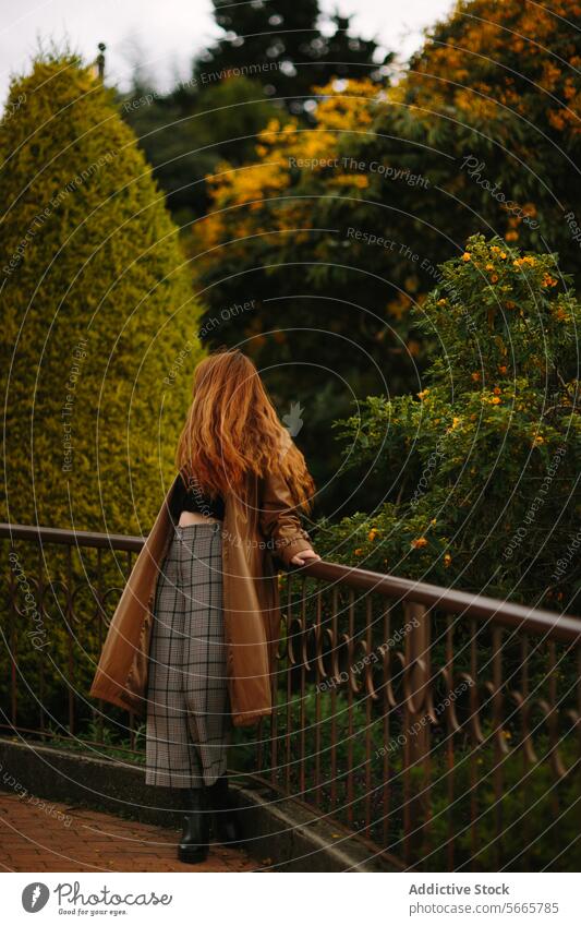 Woman enjoying a tranquil walk in a lush garden in Bogotá, Colombia woman railing vibrant greenery peace solitude setting long hair standing nature outdoors