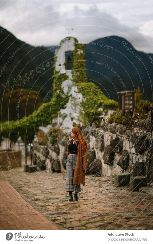 Contemplative woman at a historic stone church ruins in Bogotá, Colombia overgrown contemplative young green hills background lush thoughtful standing outdoors