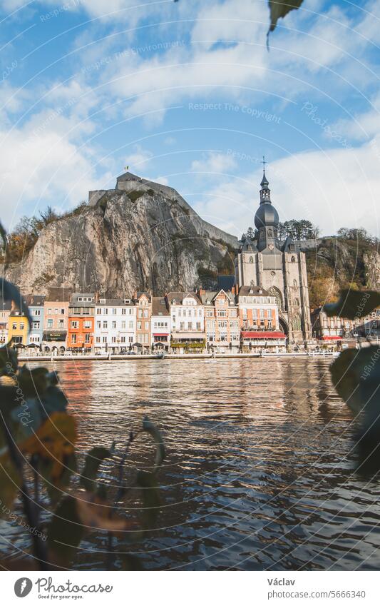 Tourist famous destination town of Dinant in Wallonia region in sunset. The town is spread around the river La Meuse with a huge rock in the middle with fortifications