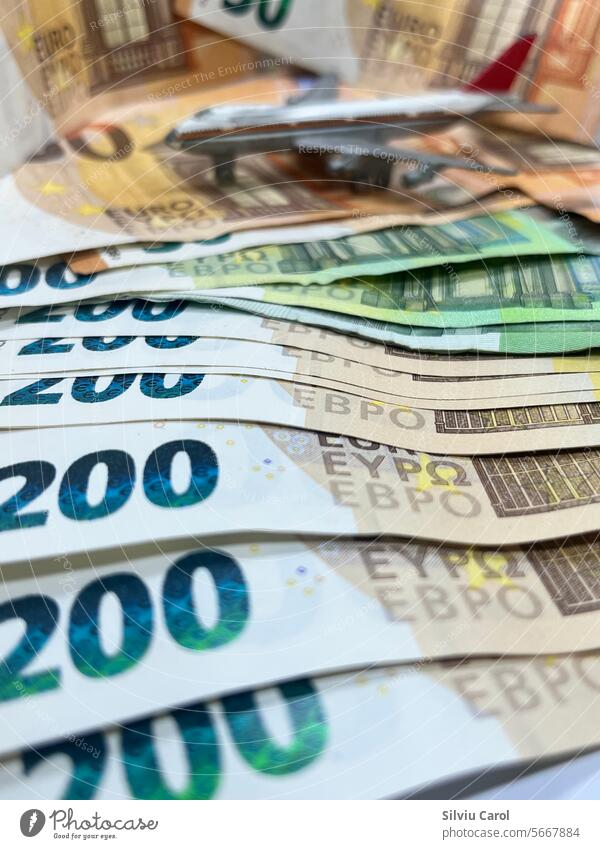 Closeup of 200 euro banknotes with a blurred plane on the back, increasing the price of air transport money flying bill aeroplane pilot isolated tacky vacation