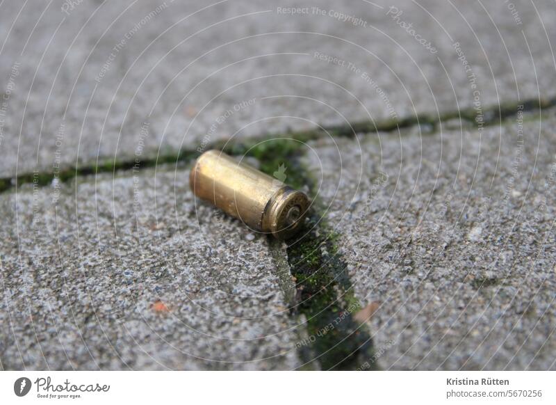 cartridge case lying on the sidewalk Husk Cartridge Munitions Caliber Street off Ground Brass fired Crime scene felonies illicit out Public Firearm Weapon