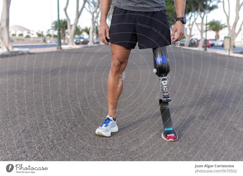 Crop runner with blade leg prosthesis during training in city sportsman amputee athlete challenge street young artificial lifestyle vitality professional