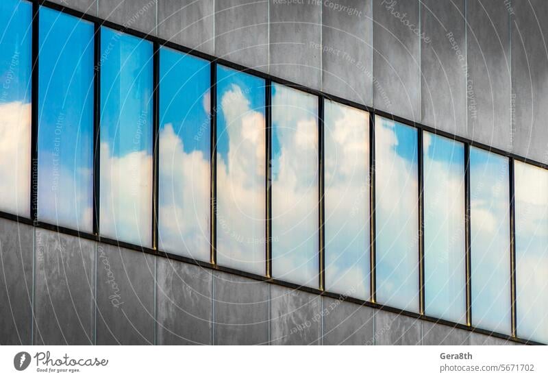 reflection of blue sky and white clouds in the windows of a gray concrete building Ukraine abstract architecture background blocks business city cityscape