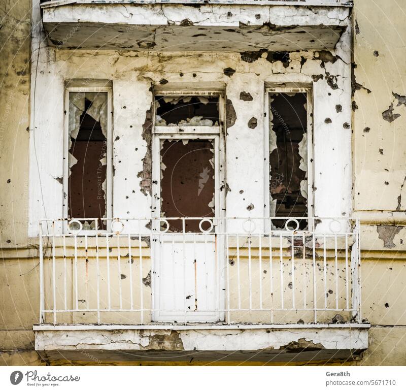 destroyed house with traces of bullets in the walls in the war in Ukraine abandoned architecture balcony brick broken building bullet holes city conflict