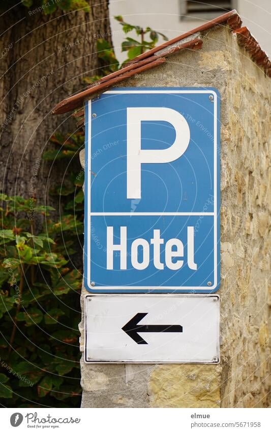 blue sign P Hotel with arrow on a wall parking sign Hotel parking lot for hotel guests only Parking lot Parking lot for hotel guests limited parking