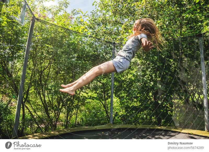 Girl enjoy bouncing on a trampoline outdoors activity air bounce child childhood childish danger dangerous emotion energetic energy enjoyment excitement
