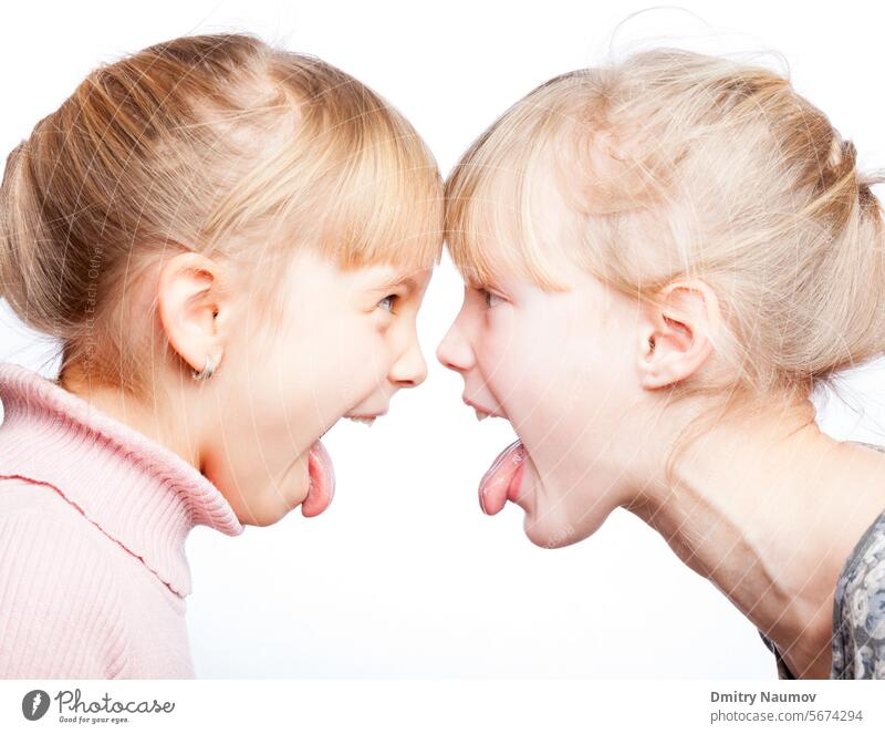 Children sticking out tongues head to head Face To Face arguing bad behavior blonde caucasian child childhood children communication conflict enmity expression