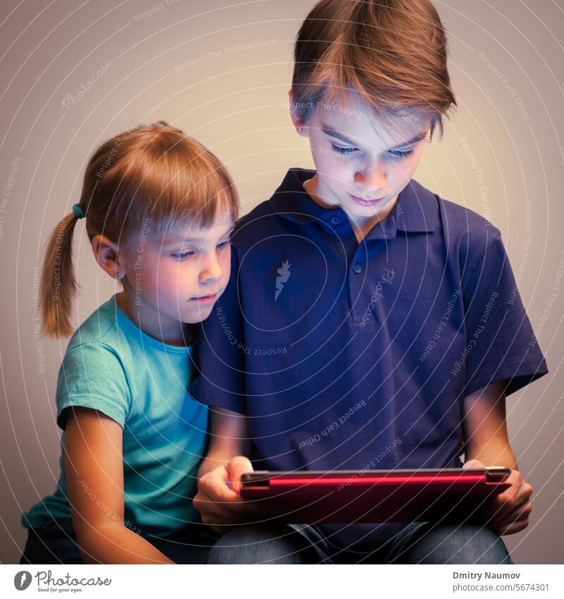 Siblings using a tablet computer Half-sibling addiction boy brother casual clothing caucasian childhood children cooperate cute device digital education