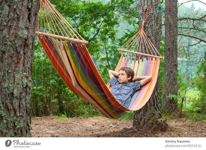 Child relaxing in hammock outdoors 12 years Serene People boy calm camp camping campsite caucasian child childhood comfortable day dreams enjoy forest