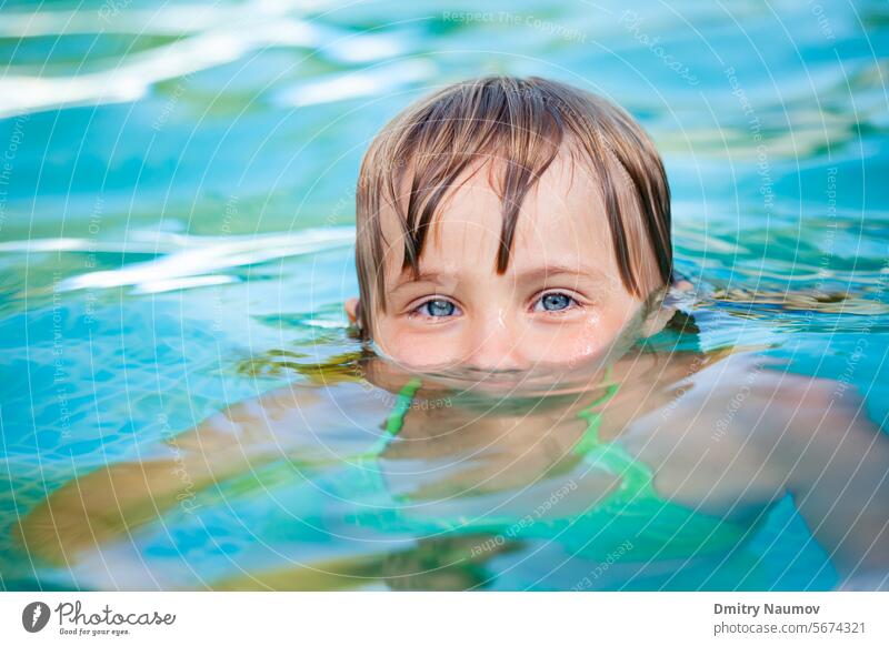 Child swimming in a pool Looking At Camera activity backyard blue caucasian child childhood cute fun garden girl head kid leisure lifestyle little outdoors play