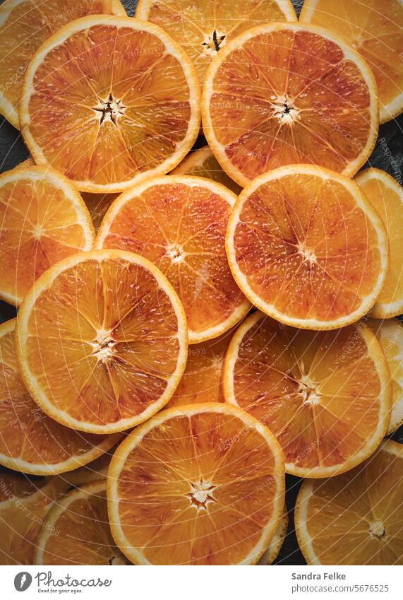 Blood oranges cut into slices and stacked to fill the picture. blood oranges Colour photo Food Nutrition Vegetarian diet Organic produce Healthy Fresh Delicious
