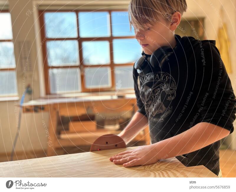 Boy in the workshop carpentry Joiner Grinder Random orbital sander Hand sander Craft (trade) Learn a trade careful grind woodwork Child Study