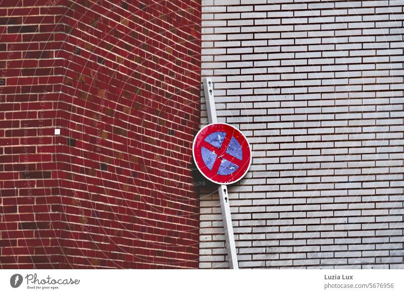 No stopping sign leaning wearily in the corner Signs and labeling Road sign No standing Lean obliquely Brick wall Red White red and white Bans Clearway Signage