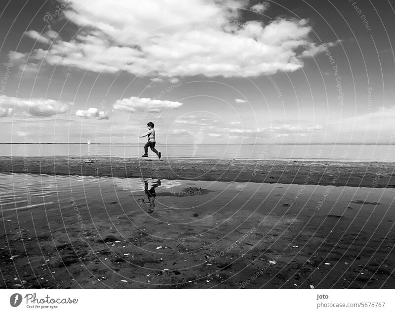 Boy runs along the sea spieglung Ocean Northern Germany Maritime Baltic Sea Beach bank frisky Running Jump playfulness Playing Joy Ease Infancy weightless Easy