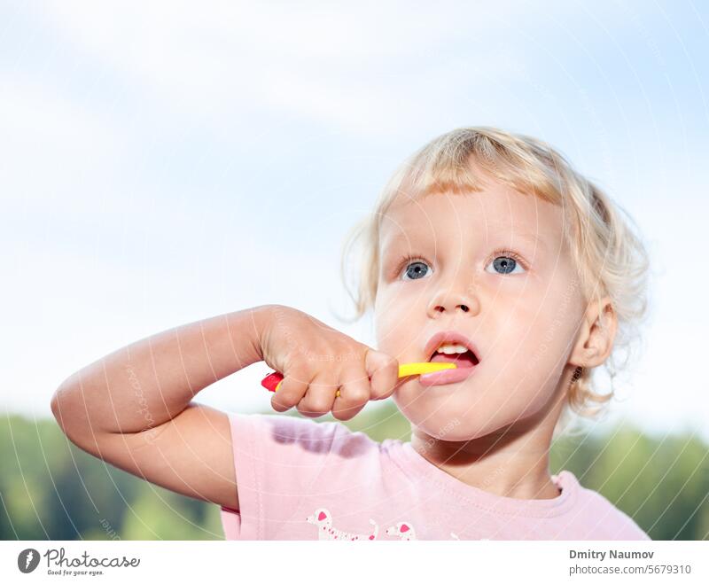 Little girl brushing teeth 2 years blonde care caucasian child childhood clean cleaning cute daily dental everyday face hand head health care healthcare healthy