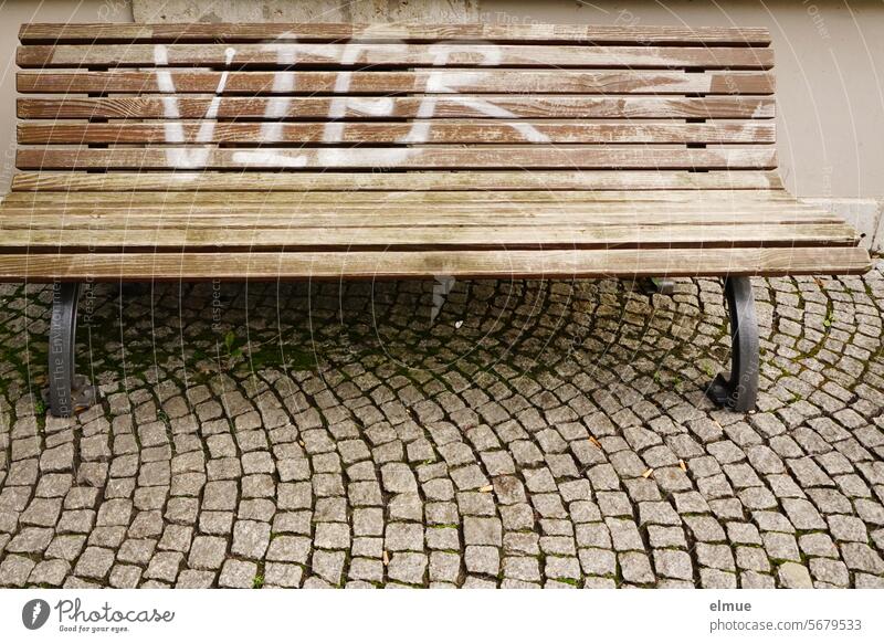 Empty wooden bench with FOUR written on it on a paved path Bench Seating Wooden bench four paving rest Daub wooden slats Loneliness Blog Wait Roadside cabaret