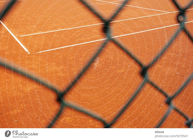 View of an empty tennis court through a wire mesh fence Tennis court Playing field Play tennis Sand place Sports Sporting Complex do sports Blog