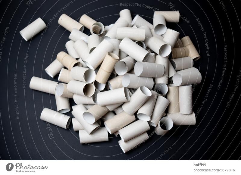 Close-up of a large pile of empty toilet paper rolls against a black background Toilet paper roll Empty Coil paperboard Paper role used minimalism Still Life