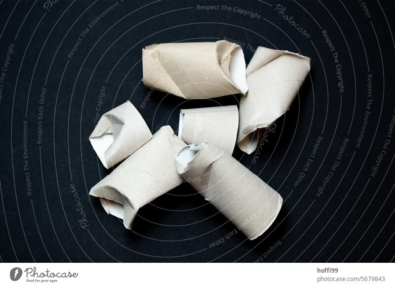 Close-up of a small pile of empty, dented toilet paper rolls against a black background Toilet paper roll crumpled demolished Empty Coil paperboard Paper role