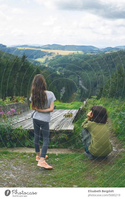 Two kids, a boy and a girl, looking into the distance on a forest vacation children holidays trip Sauerland nordrhein-westfalen Nordrhein Westfalen Germany NRW